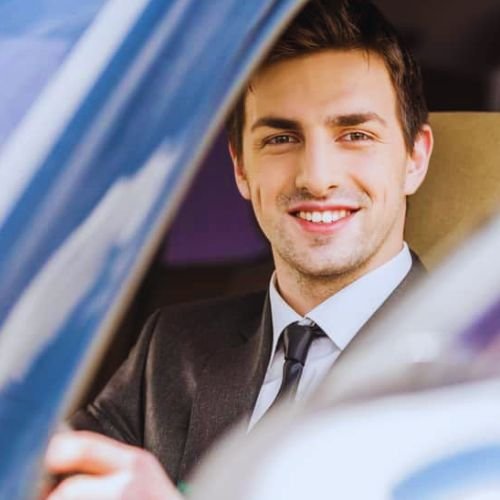 An expert chauffeur of BNL Boston Limo sitting in a luxury limo.